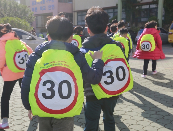 20일 경남 창원시 성산구 안민초등학교에서 학생들이 현대위아가 기증한 어린이용 안전 가방 덮개를 씌운 가방을 메고 하교하고 있다. 현대위아는 내년 1학기 개학 전까지 전국 사업장 인근 초등학교에 2만여개의 안전 가방 덮개를 배포할 계획이다. (사진=현대위아)