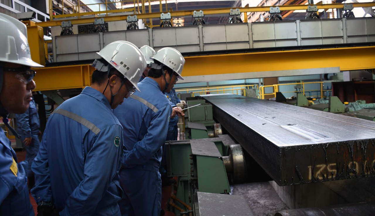 준공식 참석자들이 스카핑된 슬라브 표면을 직접 살펴보고 있다.