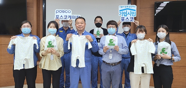 포스코케미칼이 언택트 봉사활동을 통해 제작한 신생아 옷을 지역 아동복지시설에 전달했다. 포스코케미칼 민경준 사장(사진 앞줄 왼쪽에서 세번째) 등 봉사활동에 참여한 임직원 모습.ⓒ포스코케미칼