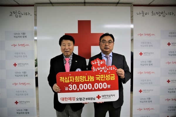 서정의 대한적십자사 부산지사 회장(왼쪽), 오형근 대한제강 부회장이 희망나눔 성금을 전달하고 기념촬영을 하고 있다.