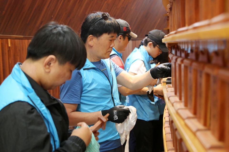 현대제철 가족봉사단이 호국보훈의 달 맞아 나라사랑공원 방문한 후 나라사랑공원에 안치된 908위의 위패를 정성스럽게 닦고 있다./ 현대제철 제공
