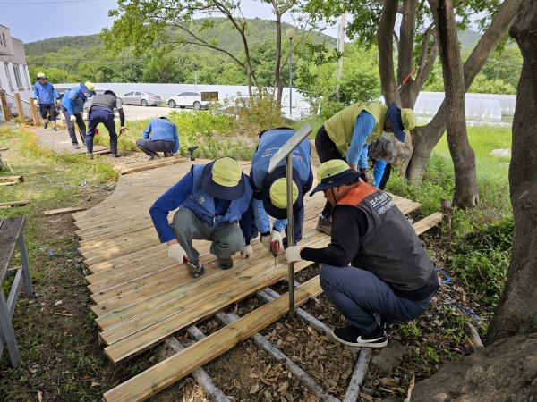 5월 25일 조경가꾸기봉사단이 좋은이웃마을 노인복지센터에서 노후된 정원 데크를 신품으로 교체하고 있다. 포스코 제공.