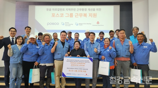 포스코 노사 관계자들이 몽골 자르갈란트 지역 목축농가 주민들에게 포스코 구형 근무복을 전달하고 기념사진을 찍고 있다. 포스코 제공.