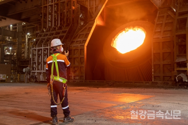 광양제철소의 한 직원이 제강공장에서 전로에 쇳물이 장입되는 모습을 확인하고 있다. 포스코 제공.