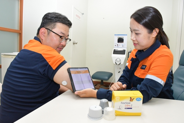 포항제철소 혈당 관리 프로그램에 참여한 직원이 전용앱에 기록된 실시간 혈당을 확인하고 있다. 포스코 제공.