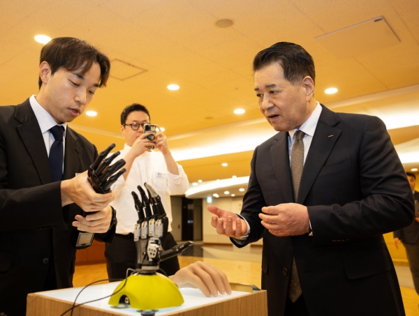 포스코1%나눔재단이 지난 20일 서울 포스코센터에서 상이 국가유공자 및 현직 소방관·군인에게 첨단보조기구를 전달했다. 사진은 로봇 의수를 살펴보는 장인화 포스코1%나눔재단 이사장 모습. /포스코