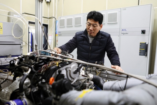 한국기계연구원 친환경모빌리티연구실 박철웅 책임연구원이 암모니아 엔진을 살펴보고 있다.  (사진=기계연구원)