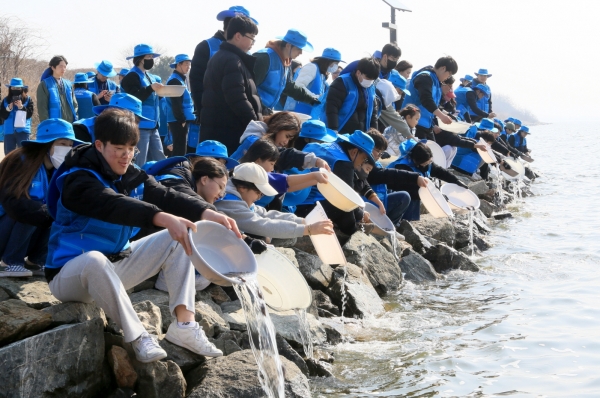 현대제철 해피프리즘 가족봉사단 7기가 22일 석문호 일원에서 발대식을 갖고 세계 물의 날을 맞아 치어를 방생했다. 출처=현대제철