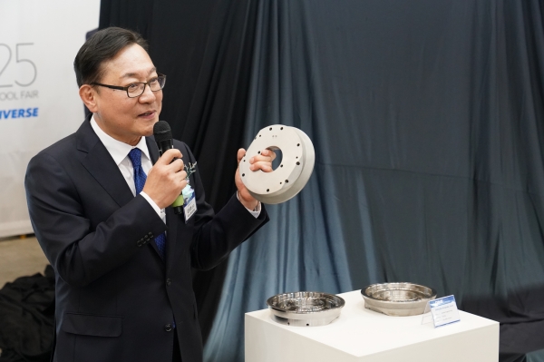 'DIMF 2025' DLX 언베일행사에서 김원종 대표이사가 적층제조로 제작된 부품을 들어보이고 있다. (사진=DN솔루션즈)