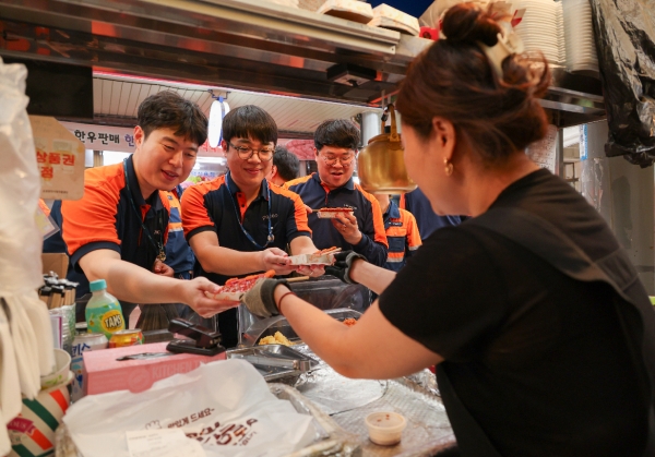 포항제철소 직원들이 대해불빛시장에서 음식을 사고 있다. /포스코
